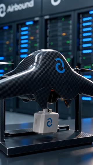 A carbon-fibre drone on a stand in a server hall.